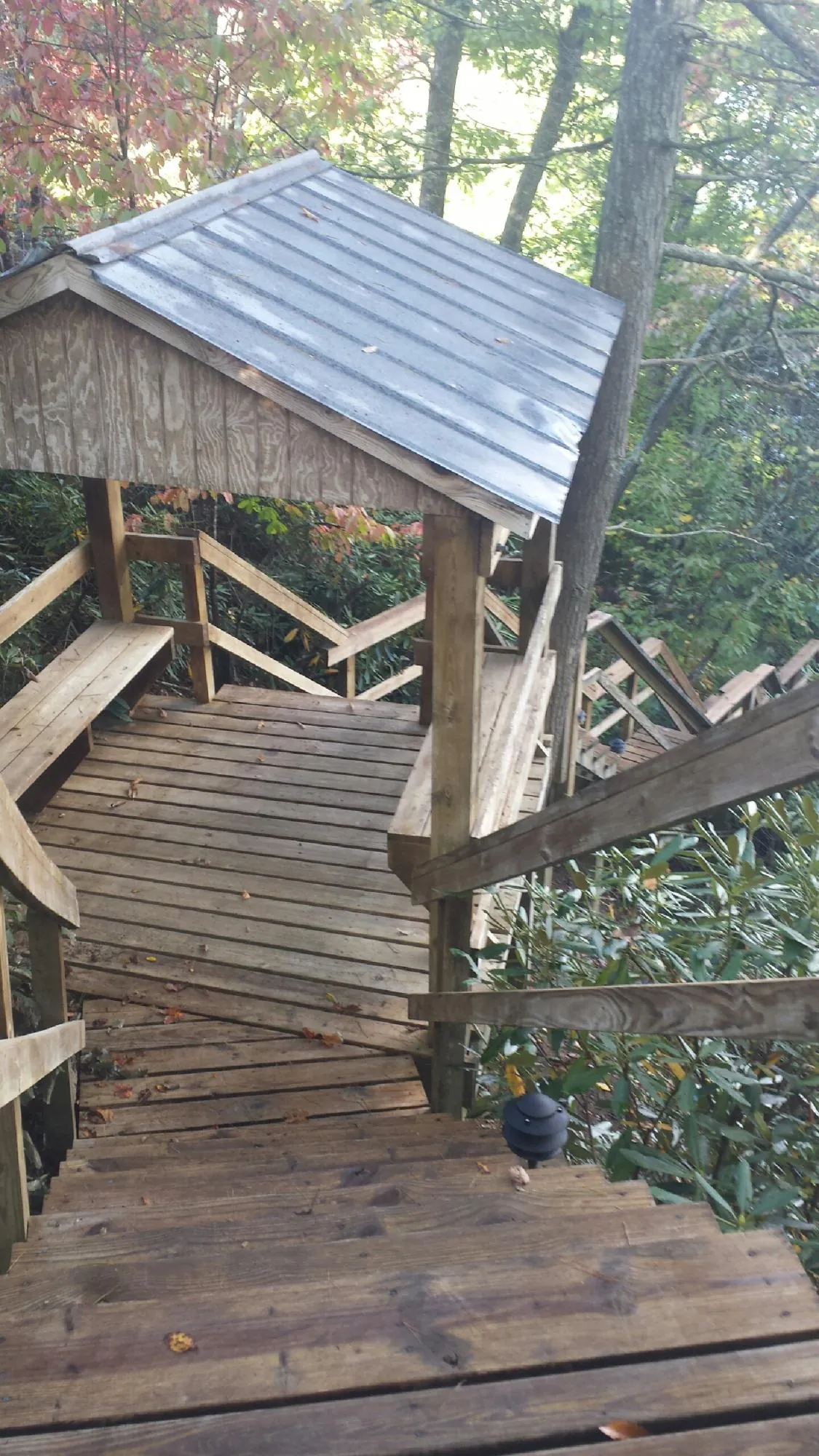 Metal roofed shelter over wooden steps on a wooded walkway — Skylight Repair & Installation work by our crew in Deltaville