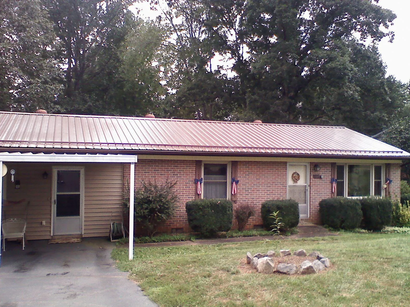 Bronze metal roof and carport on a brick ranch home — Roof Repair work by our crew in Deltaville