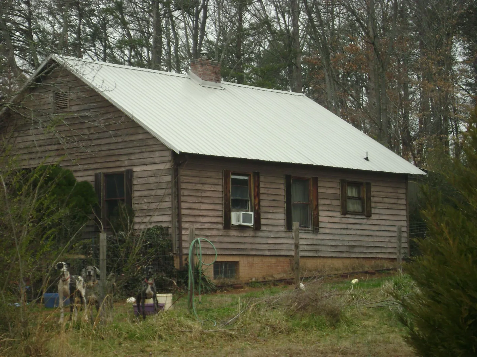 White metal roof on an old wood sided farmhouse, from a Metal Roof Installation job in Deltaville